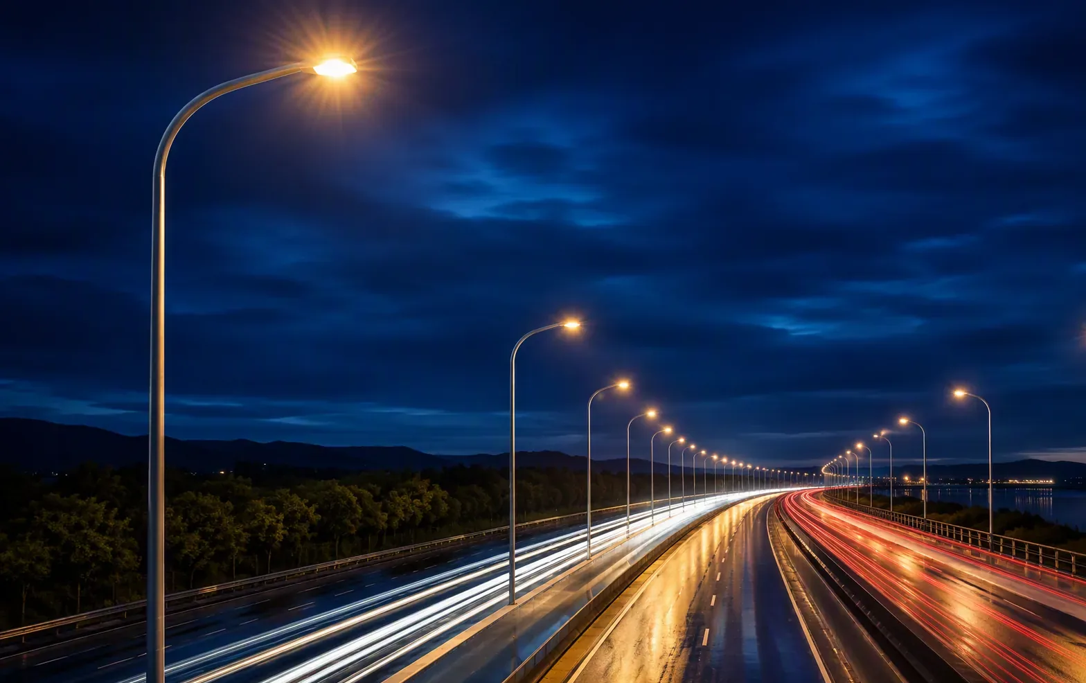 Steel street light poles lining a highway at twilight
